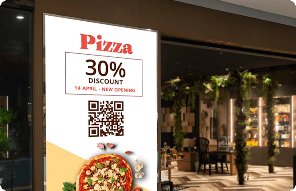 A digital signage screen displaying a discount for pizza with QR code.