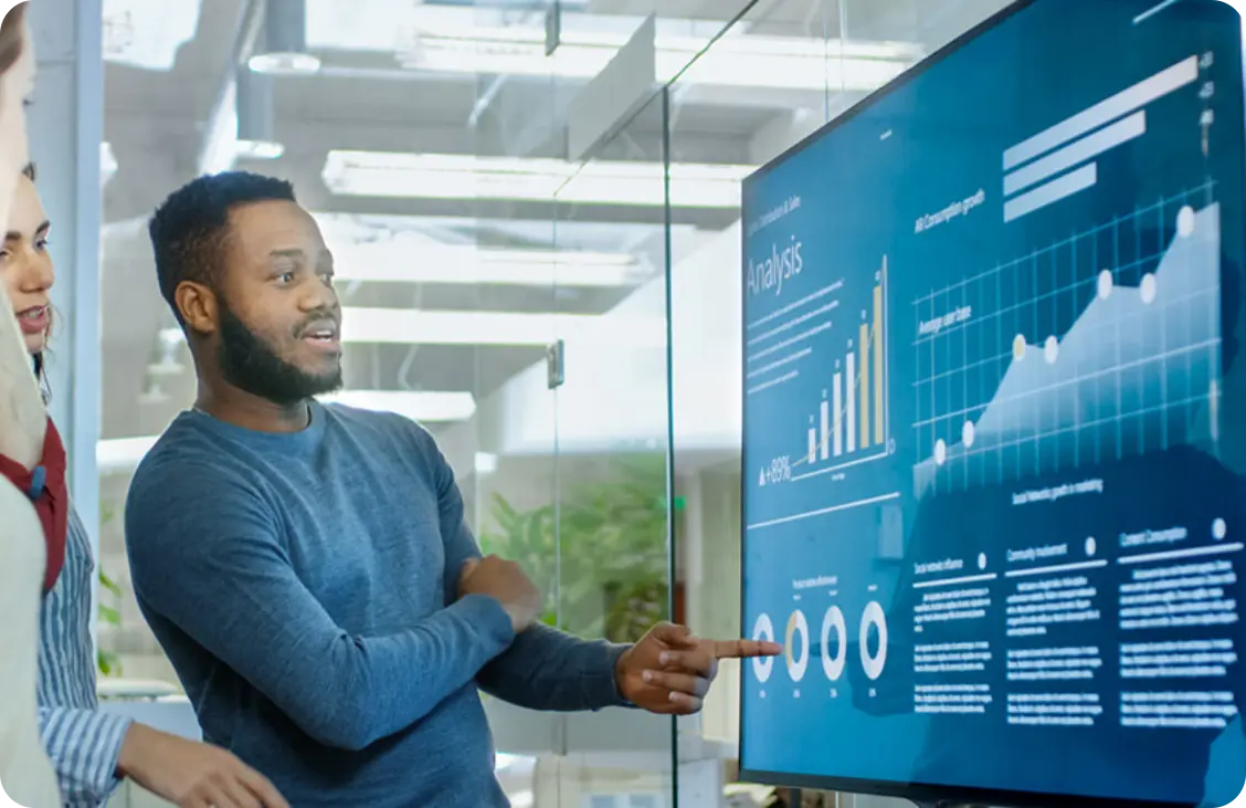 A group of people having a discussion in front of a TV dashboard display with the contents being set up by Wioplex Digital Signage Software.