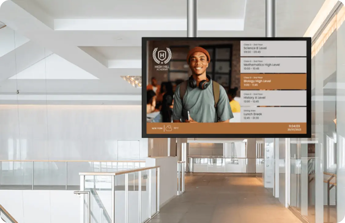 A digital signage screen installed on the ceiling of a university shows the curriculum.